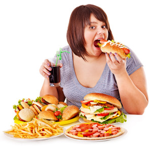 Overweight woman eating fast food.